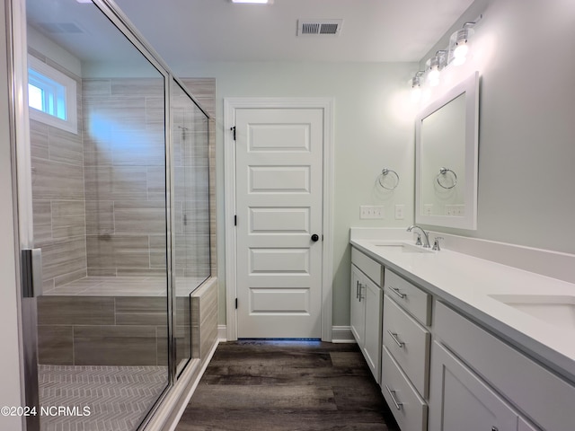 bathroom featuring vanity, hardwood / wood-style flooring, and a shower with shower door