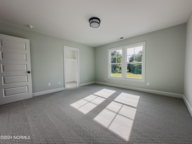 unfurnished bedroom featuring a walk in closet and a closet