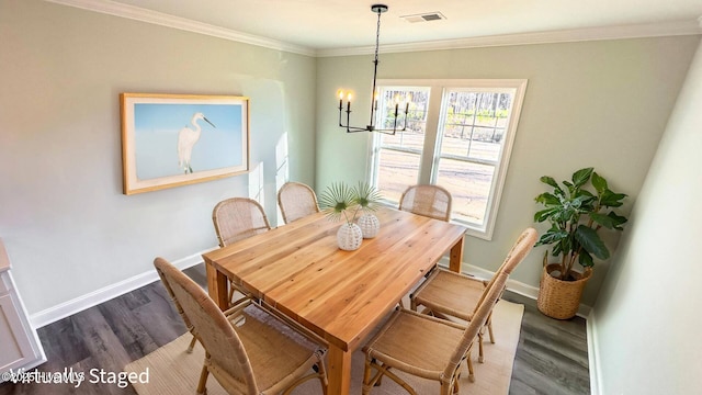 dining room with hardwood / wood-style flooring, ornamental molding, and an inviting chandelier