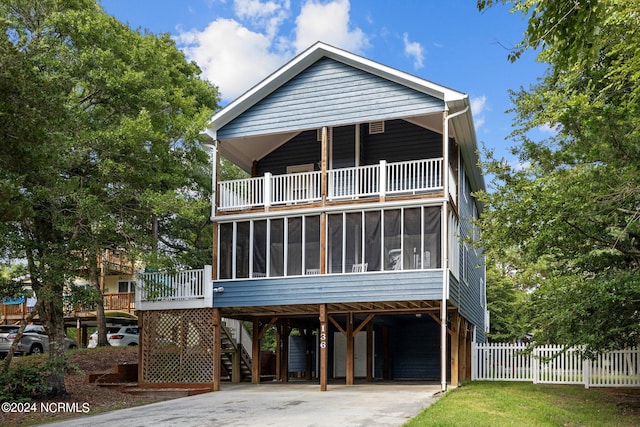 coastal inspired home with a carport and a sunroom