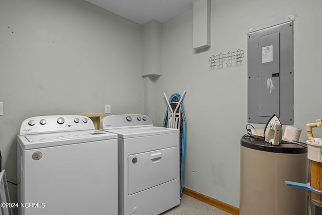 washroom featuring electric panel, water heater, and washer and clothes dryer