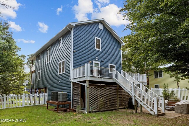 rear view of house featuring a yard and a deck