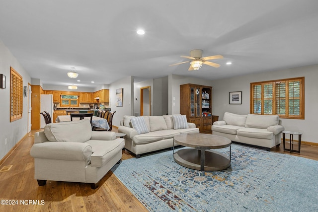 living room featuring light hardwood / wood-style floors and ceiling fan