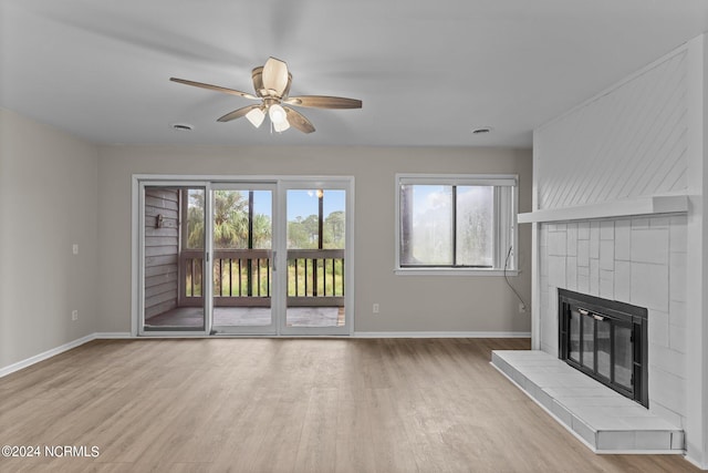 unfurnished living room with light wood-type flooring, a fireplace, and ceiling fan