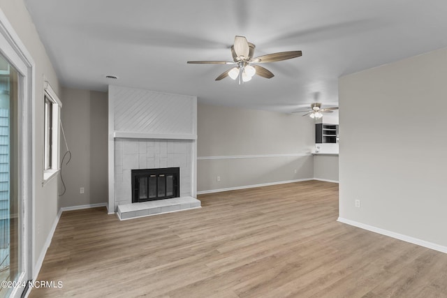 unfurnished living room with a fireplace, light hardwood / wood-style floors, and ceiling fan