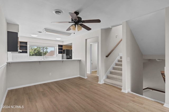 unfurnished living room with ceiling fan and light hardwood / wood-style floors