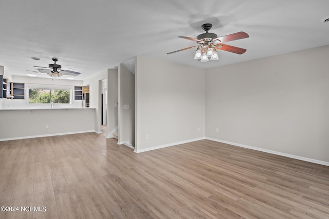 unfurnished living room featuring ceiling fan and light hardwood / wood-style flooring