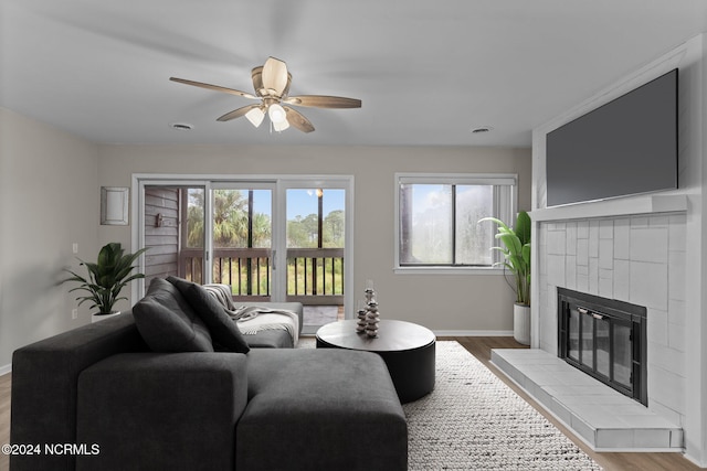 living room with plenty of natural light, hardwood / wood-style floors, and a tile fireplace