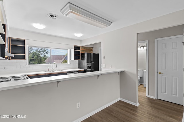 kitchen with appliances with stainless steel finishes, dark hardwood / wood-style flooring, sink, and tasteful backsplash