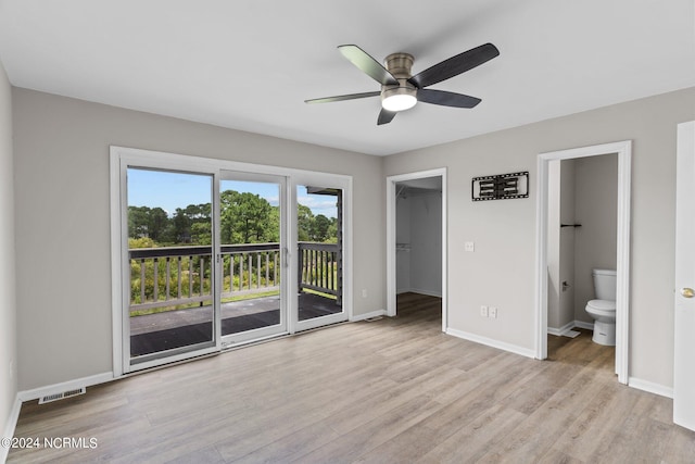 unfurnished bedroom with connected bathroom, light hardwood / wood-style flooring, a closet, a spacious closet, and access to exterior