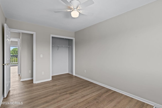 unfurnished bedroom featuring wood-type flooring, a closet, and ceiling fan