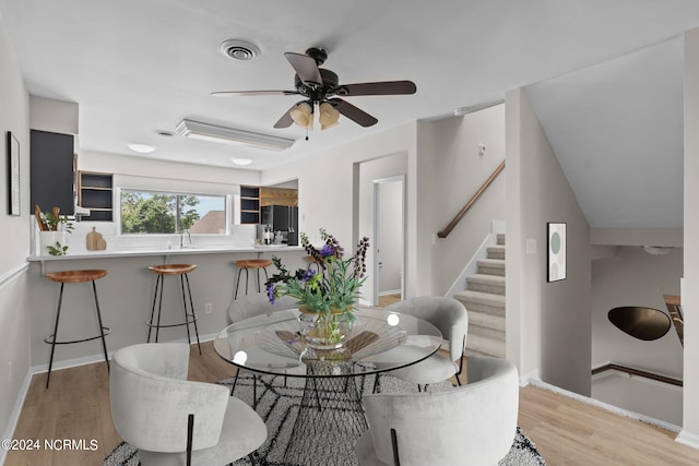 dining space with light wood-type flooring and ceiling fan