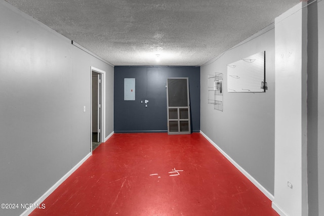 hallway featuring electric panel, a textured ceiling, and concrete floors