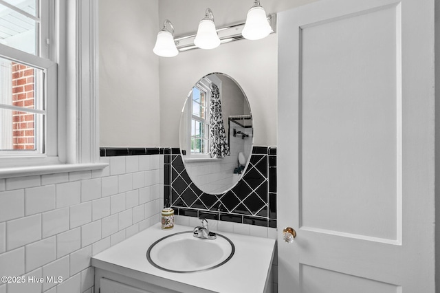 bathroom featuring vanity, tile walls, and a healthy amount of sunlight