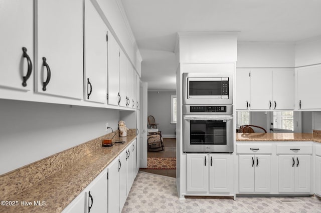 kitchen with ornamental molding, stainless steel appliances, and white cabinets