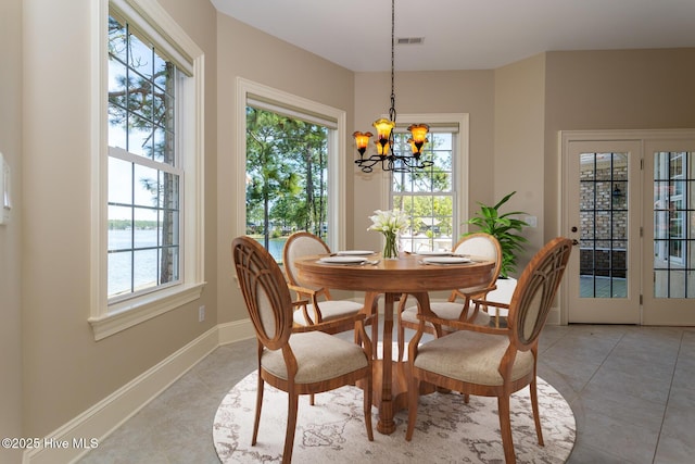 dining room with a wealth of natural light, a notable chandelier, light tile patterned floors, and visible vents