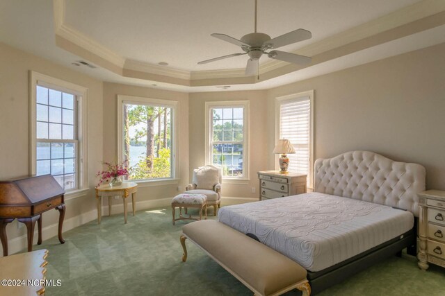 carpeted bedroom featuring a raised ceiling, crown molding, and ceiling fan