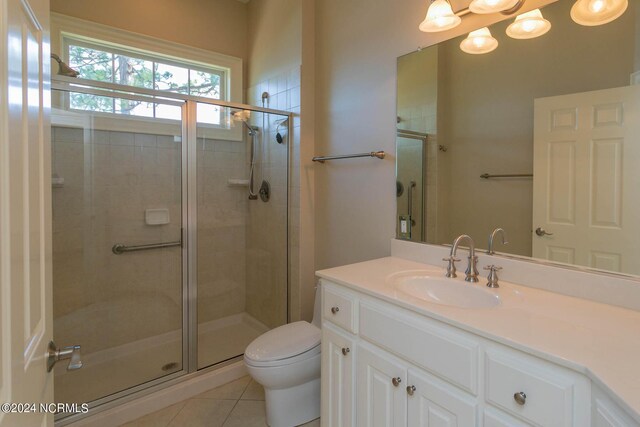 bathroom with tile patterned flooring, toilet, vanity, and an enclosed shower