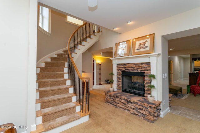 stairway with carpet floors, a fireplace, and baseboards