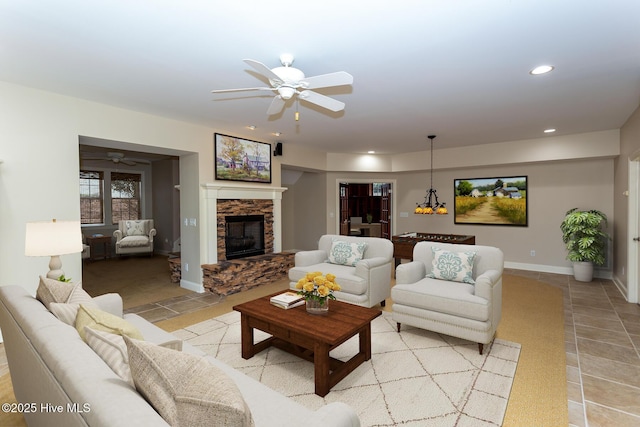 living area with baseboards, a stone fireplace, recessed lighting, light tile patterned floors, and a ceiling fan