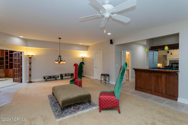 sitting room with ceiling fan with notable chandelier and light carpet