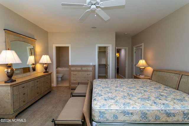 bedroom featuring light carpet, ceiling fan, a walk in closet, and ensuite bathroom