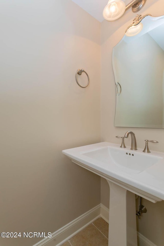 bathroom with a sink, tile patterned flooring, and baseboards