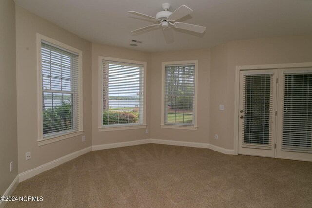 unfurnished room with light colored carpet and ceiling fan