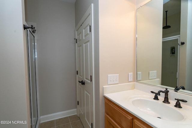 full bathroom featuring baseboards, a shower stall, tile patterned flooring, and vanity