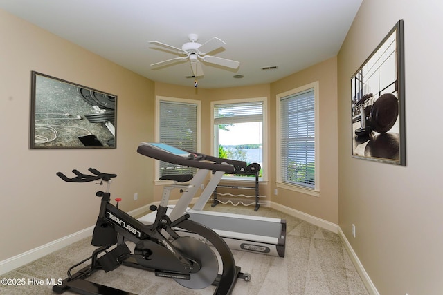 exercise area with visible vents, baseboards, carpet flooring, and ceiling fan