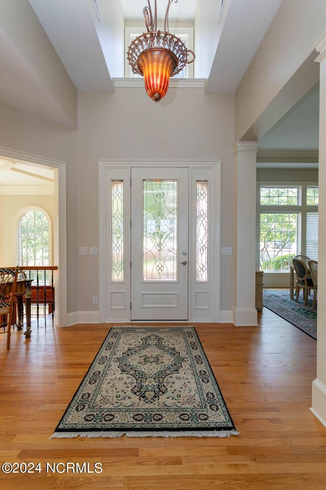 foyer with a wealth of natural light, light wood-style flooring, and a high ceiling