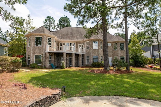 back of property featuring brick siding, a deck, and a lawn