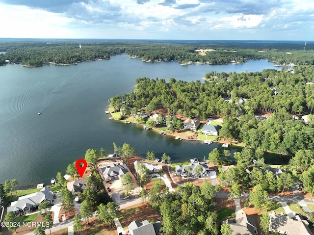 birds eye view of property with a water view and a wooded view