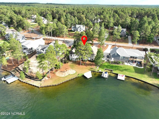 drone / aerial view featuring a wooded view and a water view