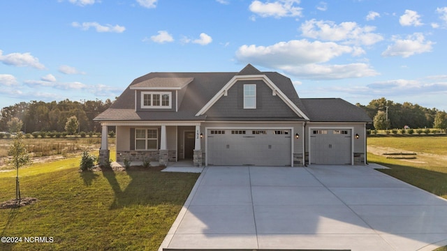 craftsman-style house featuring a garage, a front yard, and covered porch