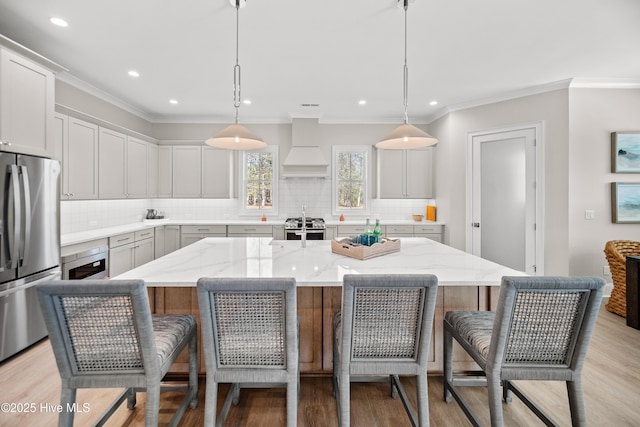 3772 Barnesmore Dr, Castle Hayne, NC 28429 - kitchen featuring appliances with stainless steel finishes, premium range hood, a breakfast bar, tasteful backsplash, and ornamental molding