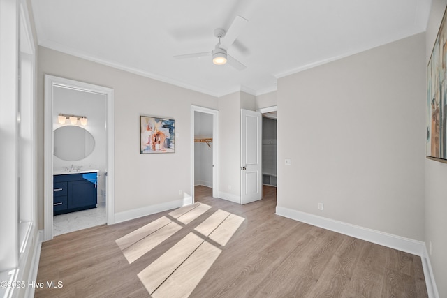 3772 Barnesmore Dr, Castle Hayne, NC 28429 - unfurnished bedroom with a walk in closet, light wood finished floors, ornamental molding, a closet, and ensuite bath
