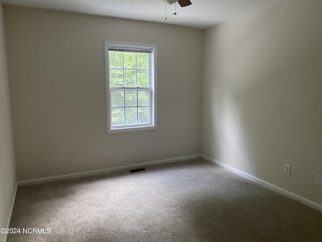 carpeted empty room featuring ceiling fan