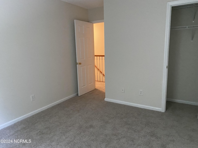 unfurnished bedroom with a walk in closet, carpet, and a closet