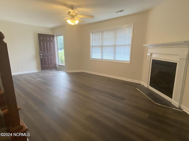 unfurnished living room with dark wood-type flooring and ceiling fan