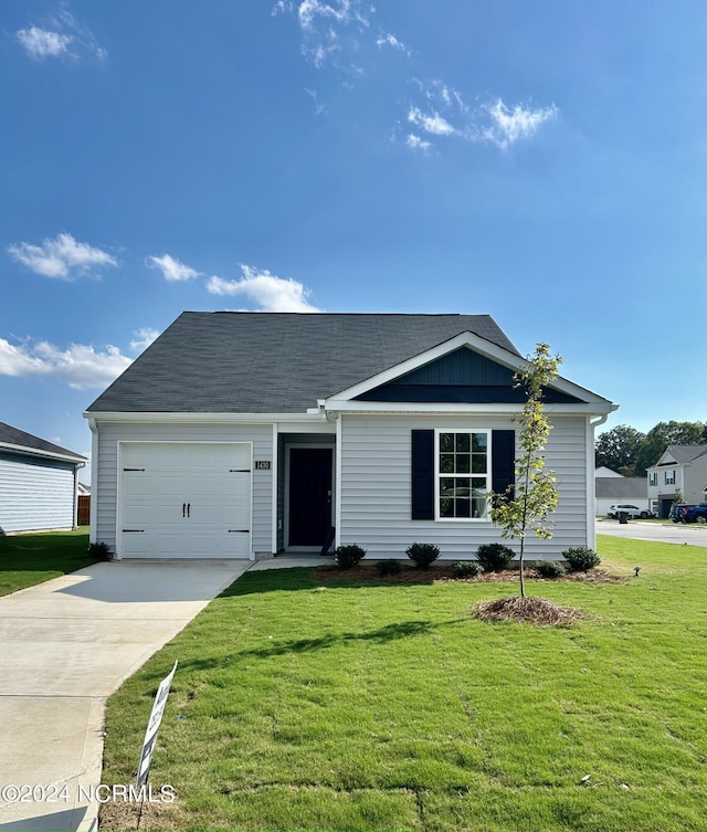 view of front of home featuring a front yard and a garage