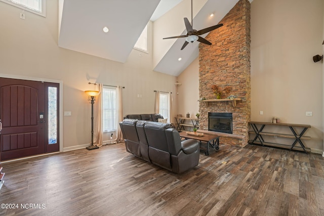 living room featuring dark wood-type flooring, a fireplace, ceiling fan, and vaulted ceiling