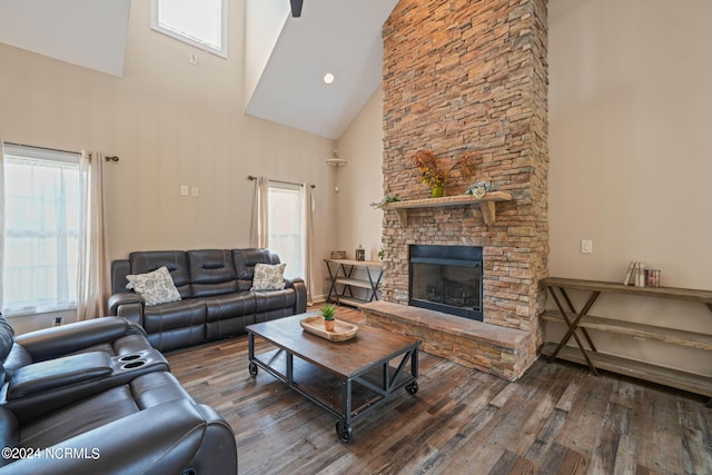 living room with plenty of natural light, dark hardwood / wood-style flooring, and a stone fireplace