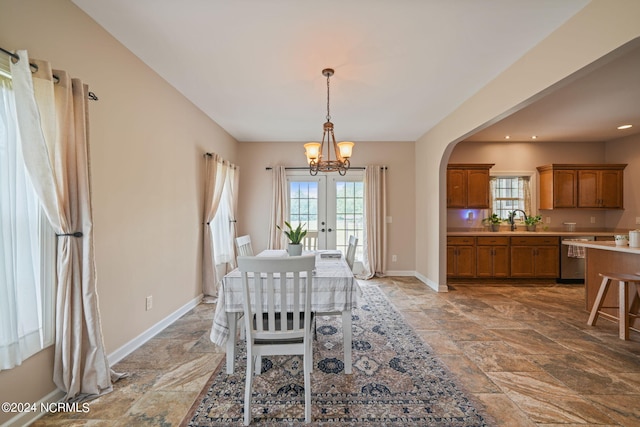 dining area featuring sink, french doors, and a chandelier