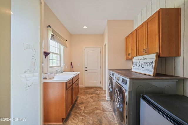 washroom with sink, cabinets, and washing machine and clothes dryer