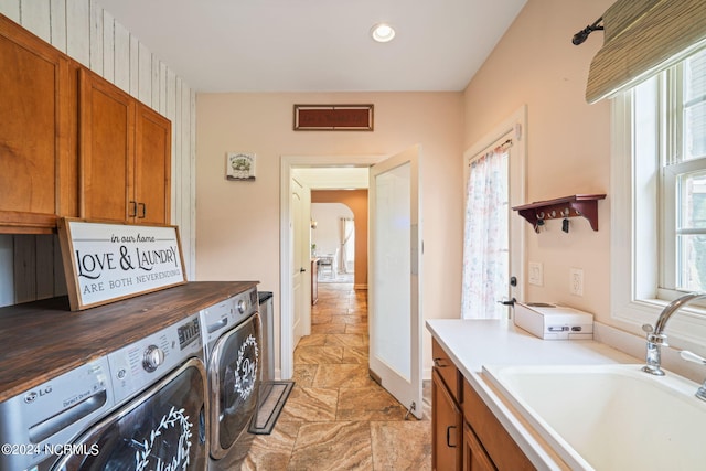 laundry room featuring cabinets, sink, and washer and clothes dryer