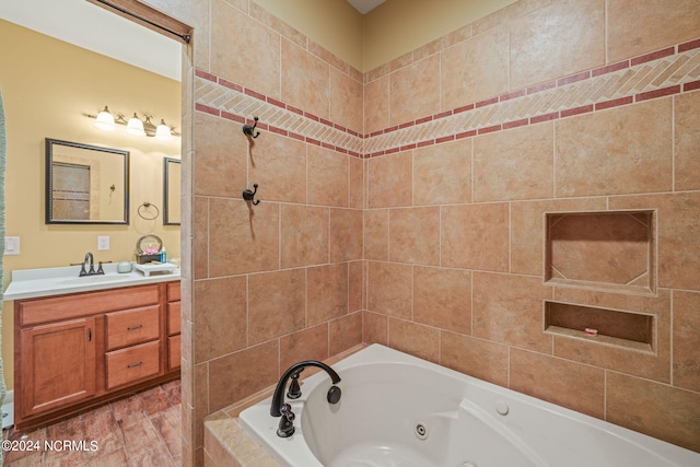 bathroom featuring vanity and tiled bath