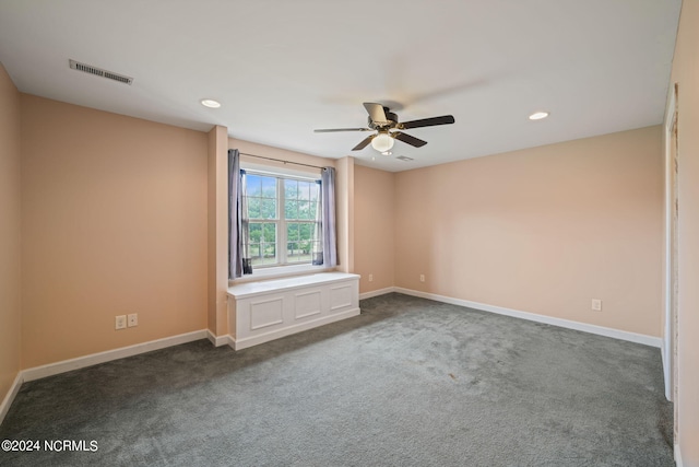 unfurnished room featuring ceiling fan and dark carpet