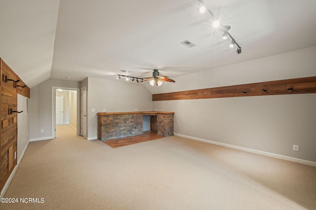 unfurnished living room with ceiling fan, vaulted ceiling, and light carpet