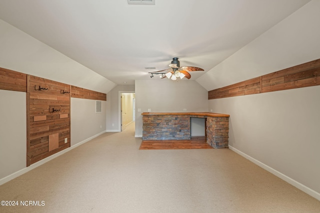 bonus room with vaulted ceiling, wooden walls, and ceiling fan